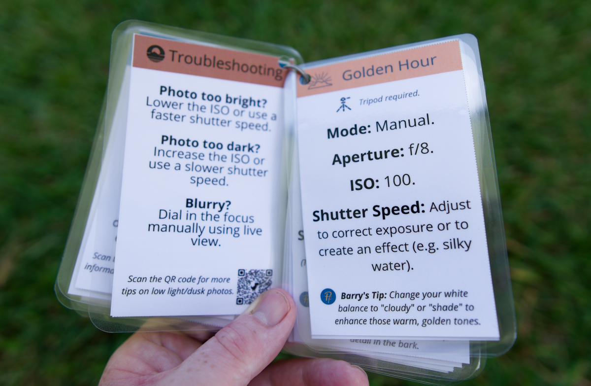 A set of nature photography cheat cards being held up by a male hand